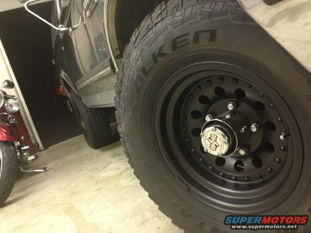 Black aftermarket wheel with Falken tire on a dark-colored Ford Bronco, close-up side view