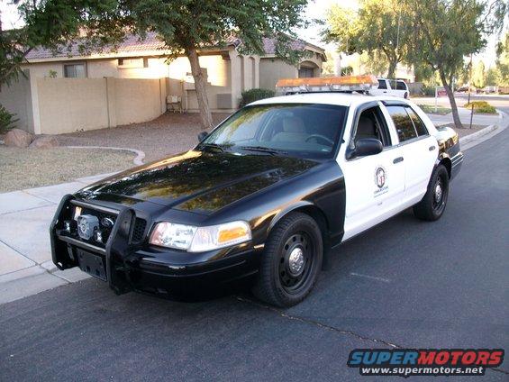 Black and white 2006 Ford Crown Victoria police car with a push bar and light bar