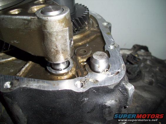 Close-up of a metal transmission component with gears and oil