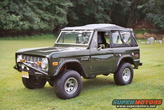 Dark green 1976 Ford Bronco with a soft top parked on grass