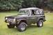 1976 Ford Bronco - This 1976 Ford Bronco, seen from a three-quarter front view, is a classic SUV with a dark green exterior and a soft top.
