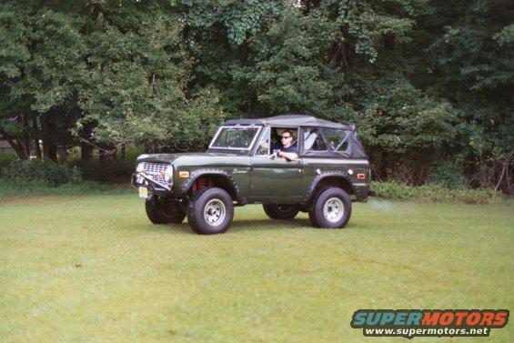 Green 1976 Ford Bronco with soft top on grassy field