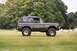 1976 Ford Bronco - This Ford Bronco is parked in a cemetery, with trees and gravestones visible behind it.
