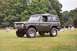 1976 Ford Bronco - A 1976 Ford Bronco sits in a grassy field with trees and gravestones in the background.