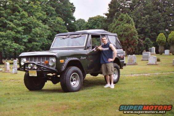 1976 Ford Bronco with a man standing by the driver's door in a cemetery. License plate reads CC47187
