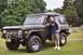 1976 Ford Bronco - A man poses with a classic green Ford Bronco in a grassy area with trees and gravestones in the background.