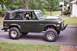 1976 Ford Bronco - This classic SUV features a dark green exterior and a black soft top, with prominent fender flares.