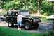 1976 Ford Bronco - A man poses with a dark green 1976 Ford Bronco, a classic SUV known for its design and off-road capabilities.