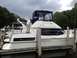 1985 Carver 326 Aft Cabin - A white aft cabin boat with blue canvas is docked, showing its side profile. The registry identifies it as a 1985 Carver 326 Aft Cabin.