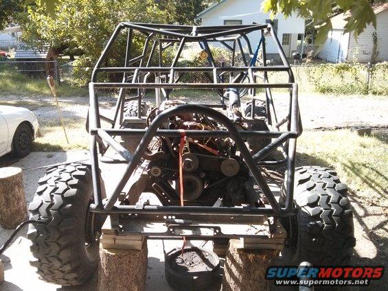 Custom buggy chassis on blocks, engine visible, large off-road tires