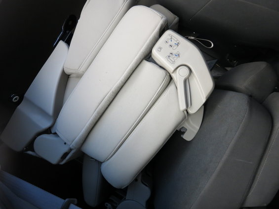 Folded light-colored car seats with a gray seatbelt visible