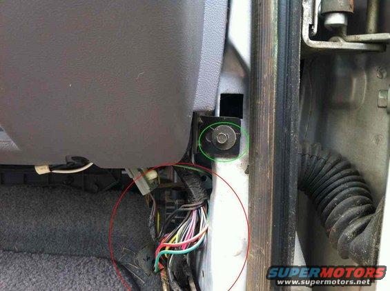 Close-up of a vehicle's interior door panel and dashboard area, showing some exposed wiring