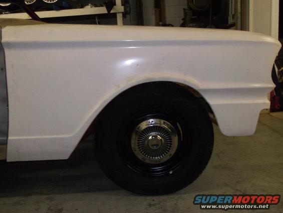 White 1964 Ford Fairlane front fender and wheel, side view, in garage