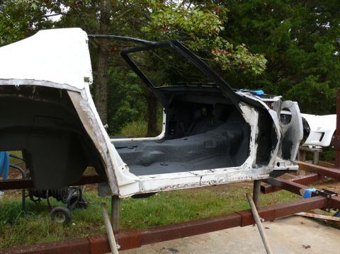 car body on stands, stripped down for restoration