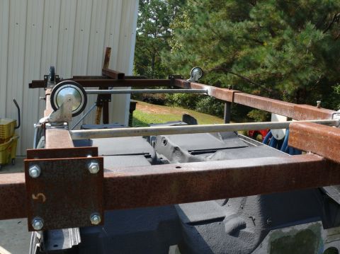 Metal frame with casters mounted over a dark surface, possibly a vehicle part