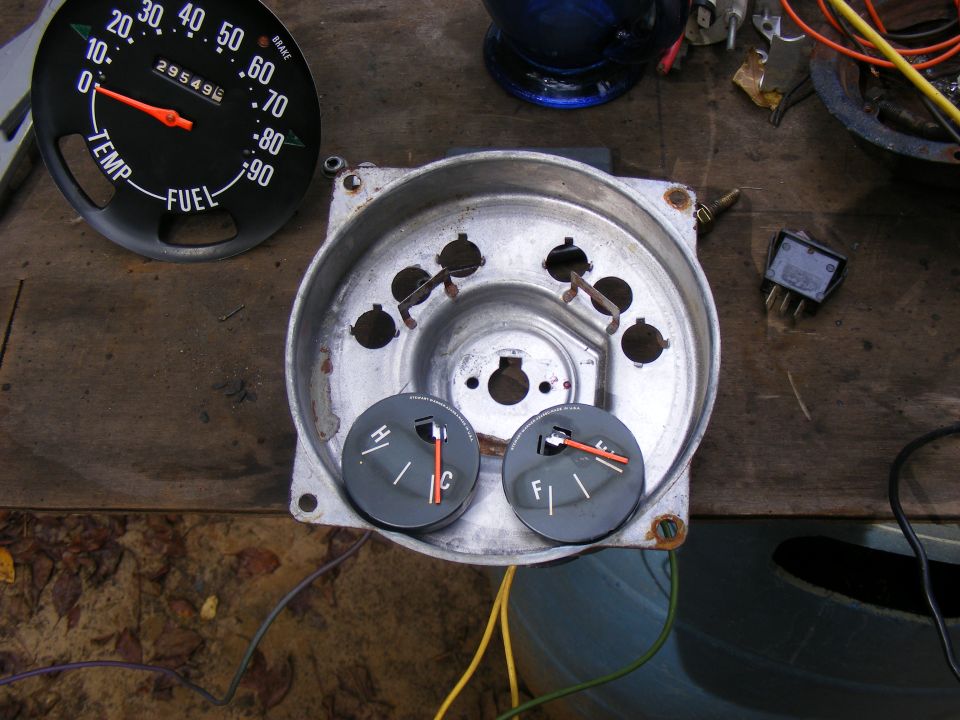 Car dashboard housing with temperature and fuel gauges, plus a separate speedometer/fuel gauge assembly