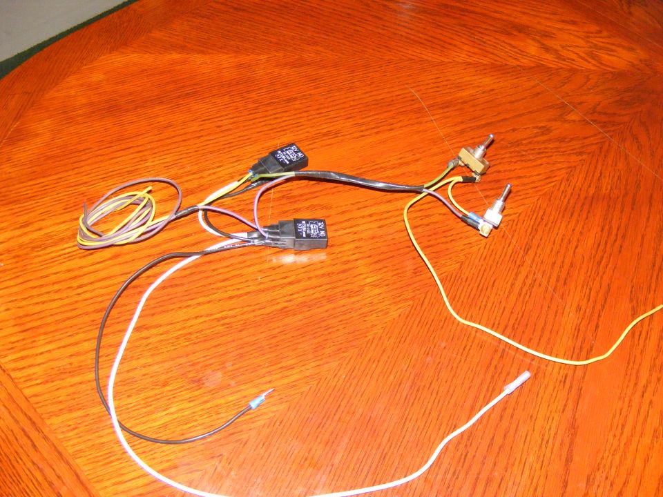 Wiring harness with two relays and two switches on a wooden surface