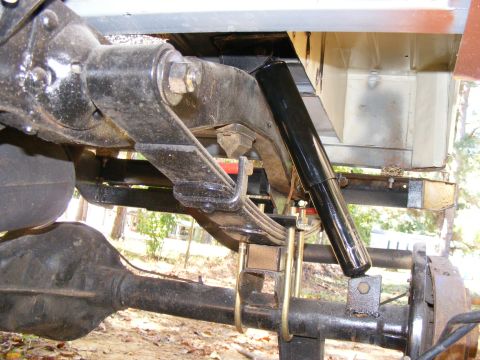 1978 Ford Bronco rear axle with leaf springs and shock absorber, showing rust and wear