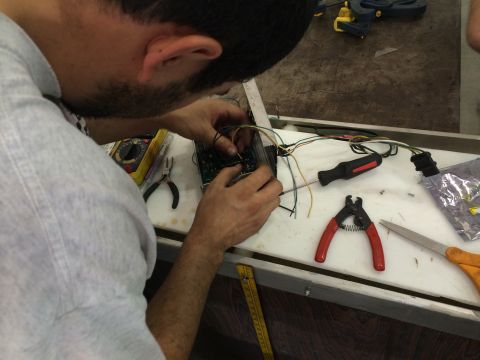 1995 Ford Probe - Mechanic works on vehicle wiring harness and electronic control unit with various tools.