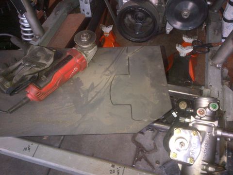 1985 Jeep CJ7 - A power grinder rests on a metal plate marked with cut lines, suggesting fabrication work.