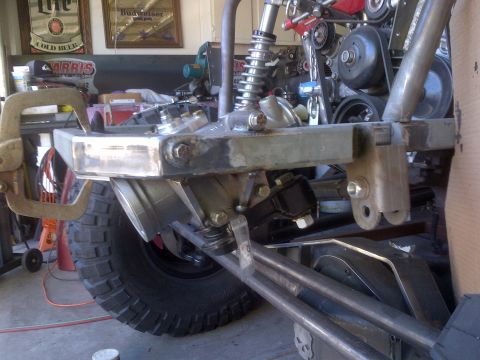 1985 Jeep CJ7 - Close-up view of a custom front suspension and bumper assembly, with a large off-road tire in the foreground.