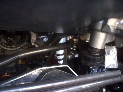 1985 Jeep CJ7 - Close-up view of the steering mechanism and suspension parts beneath a vehicle.