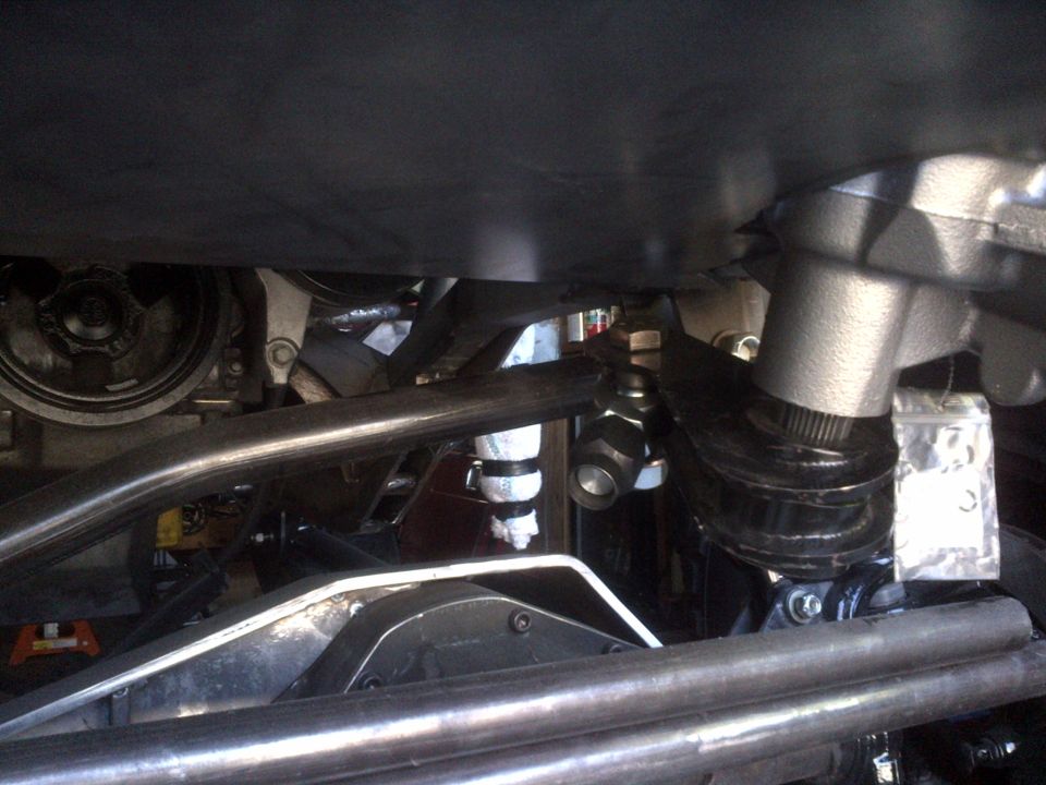 Undercarriage view of steering linkage and suspension components, with a Supermotors watermark