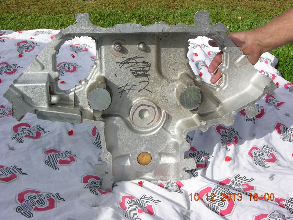 Engine block part with scribbled writing and '#2' on it, laid out on a blanket with Ohio State logos