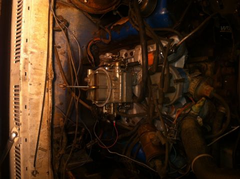 1979 Ford Bronco - Close-up view of a vehicle's engine bay, focusing on the carburetor and surrounding components.