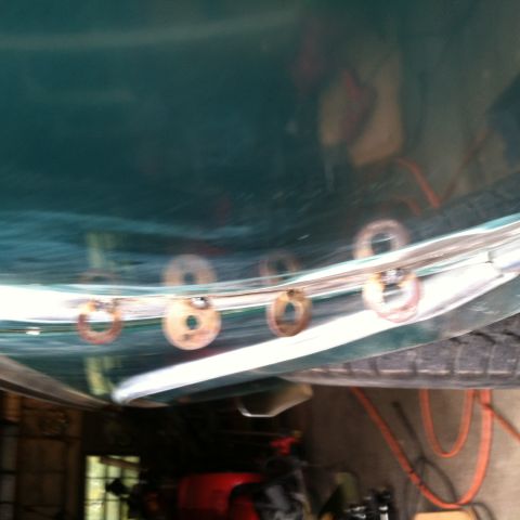 1978 Ford Bronco - Metal mounting rings are attached to a curved green panel, likely part of a vehicle's body.