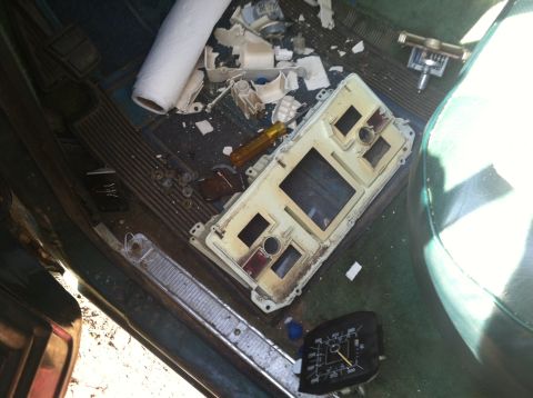 1978 Ford Bronco - The interior of a vehicle shows a disassembled dashboard with scattered parts and a roll of paper towels.