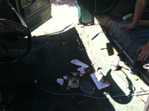 1978 Ford Bronco - The interior of a vehicle is shown with the carpet removed, revealing the floor and door panel during a restoration project.