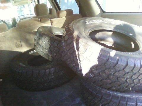1978 Ford Bronco - Spare tires are stacked in the cargo area of a vehicle.