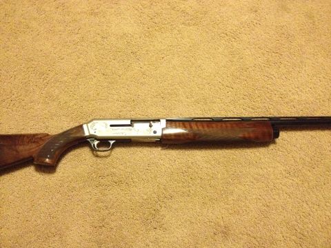 1990 Ford Bronco - A shotgun with a wooden stock and forend is shown against a carpeted background.