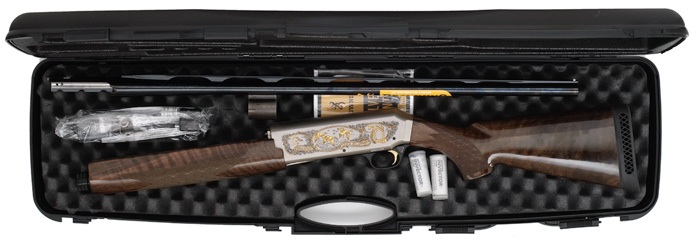 Shotgun with engraved receiver and wood stock in a black case with foam padding