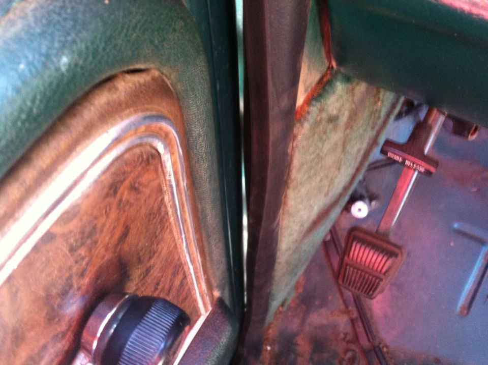 close-up of car interior showing door panel, dashboard, and pedals