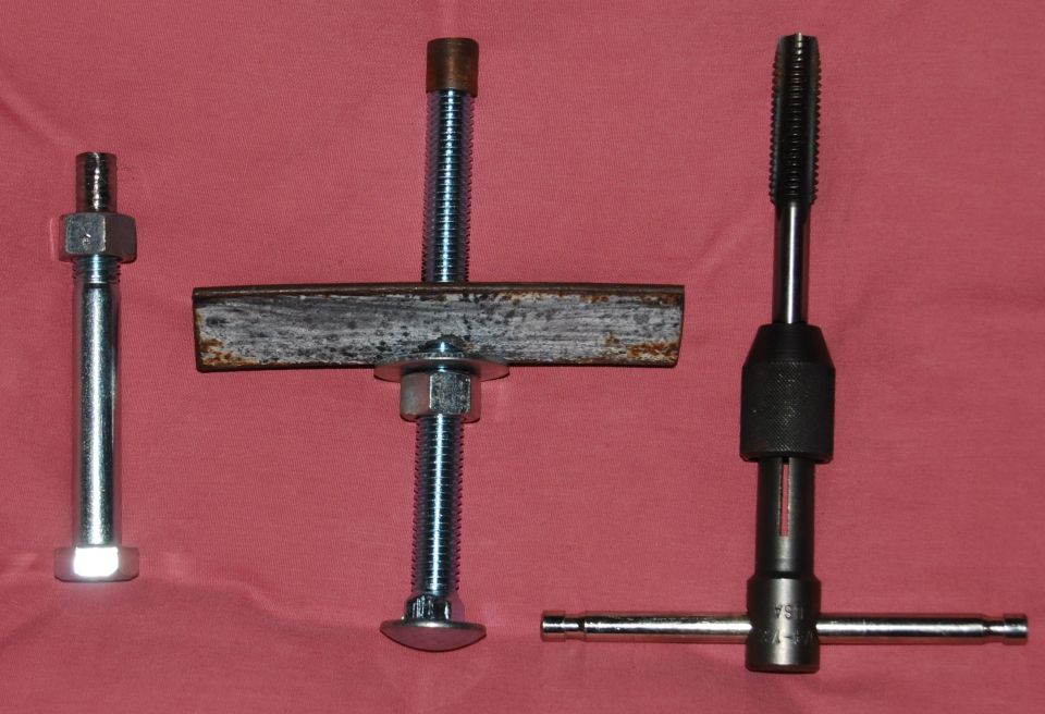 Three metal tools for starter bushing work: a bolt with nuts, a threaded rod with a metal bar and nuts, and a tap wrench with a tap