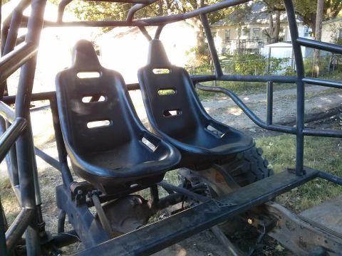 1986 Ford Bronco - Interior view of a custom off-road buggy two black bucket seats and a metal roll cage structure.