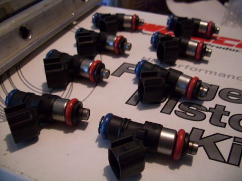 1995 Ford Probe - Multiple fuel injectors are laid out on a surface with visible text and logos.