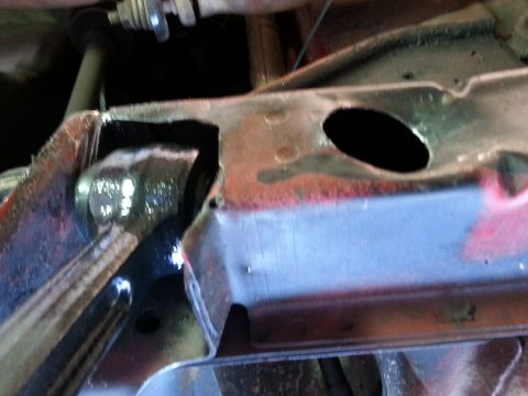 1991 Ford Festiva - A close-up view of a rusty suspension component, showing a black hole within its structure.