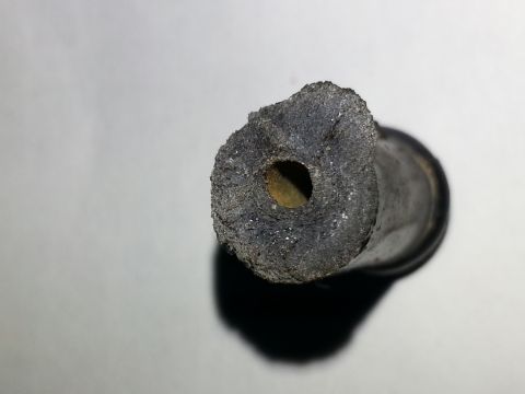 1994 Ford Bronco - Close-up view of a deteriorated rubber hose end, likely from a vehicle's cooling system, showing significant wear and buildup.