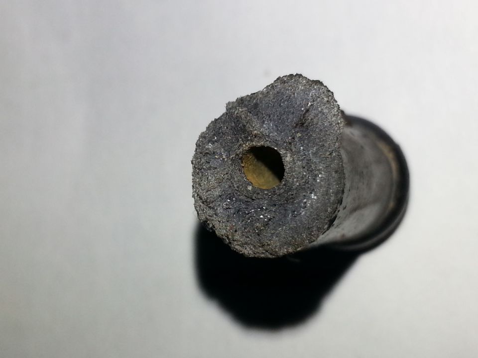 Worn rubber hose end with debris buildup