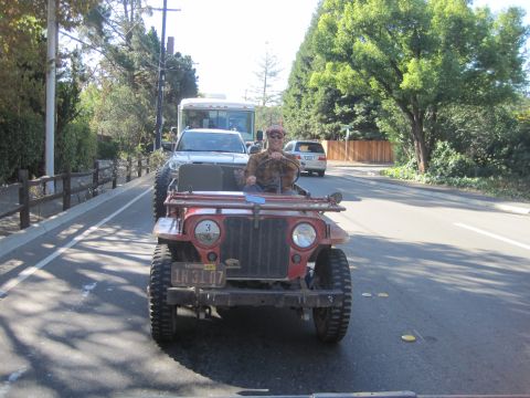 1946 Jeep CJ5 - A 1946 Jeep CJ5 is driven down a road, with other vehicles visible in the background.