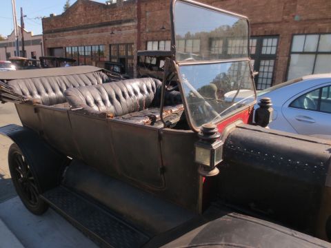 1946 Jeep CJ5 - A vintage touring car is parked on a street next to a modern vehicle.