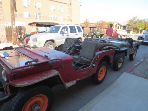 1946 Jeep CJ5 - A red 1946 Jeep CJ5 is seen towing another Jeep in a line of vehicles.