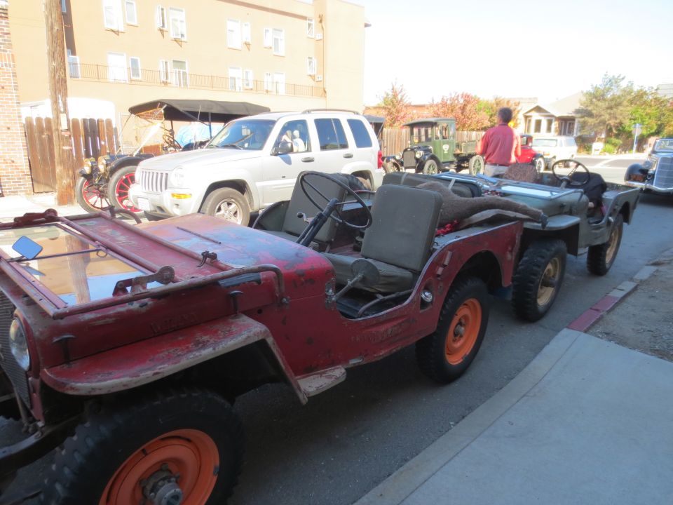 Red 1946 Jeep CJ5 towing another Jeep, side view