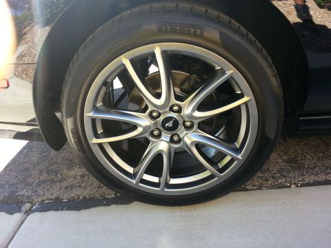 2013 Ford Mustang - Close-up of a silver 5-spoke wheel with a black Mustang emblem on a Pirelli tire.