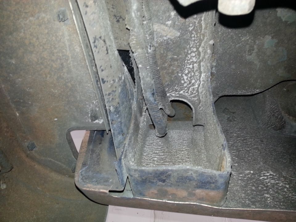 Close-up of the undercarriage of a vehicle, showing frame rails and some wiring