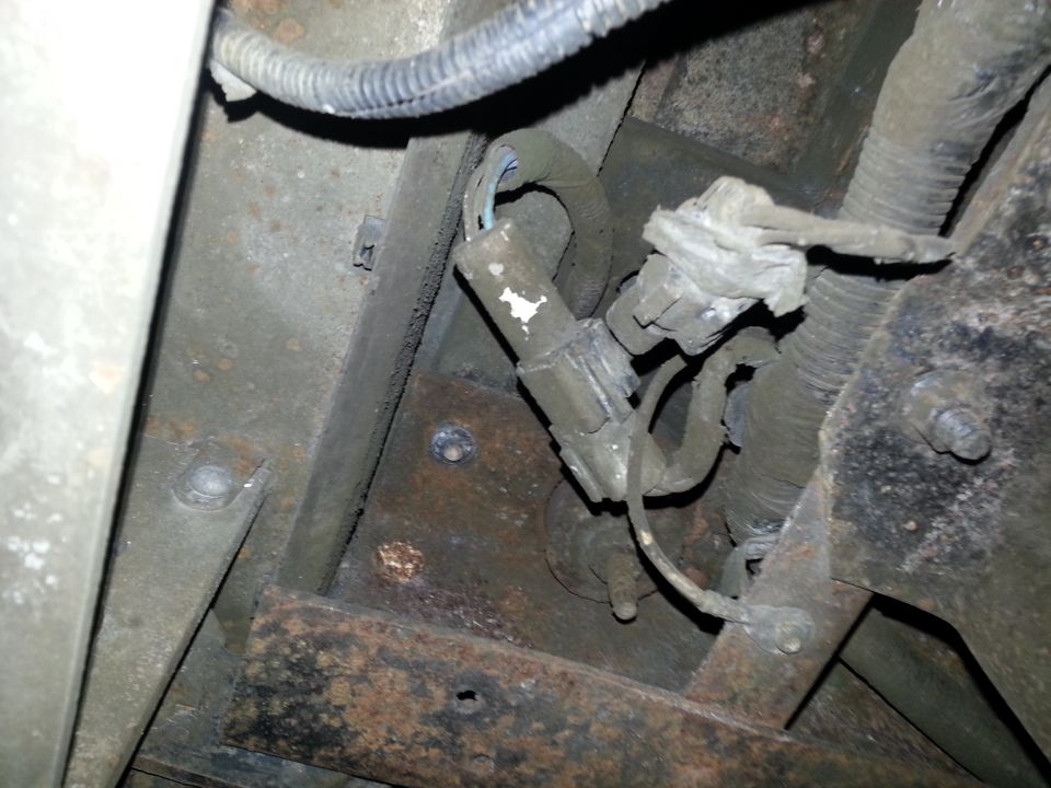 Underside frame view of vehicle showing rust corrosion and wiring