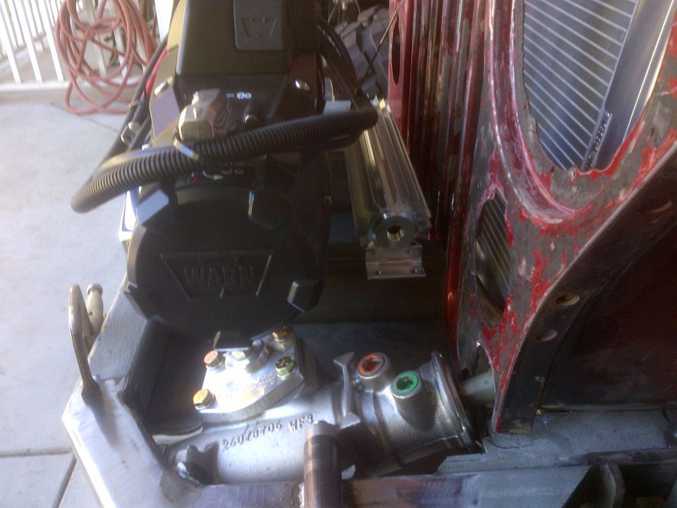 Warn winch mounted on a vehicle frame with a metal component attached